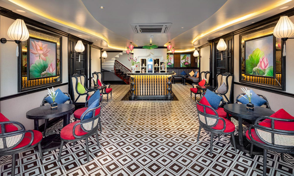 A restaurant with black checkered floors, tables and chairs on the sides, and a bar in the middle.