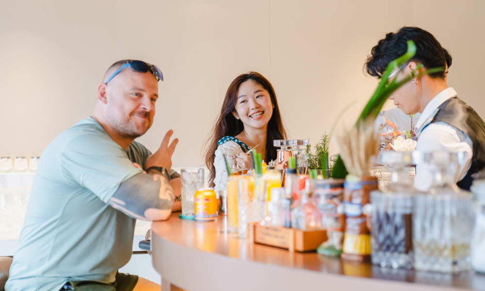 two happy guests on a bar with many drinks in front of them