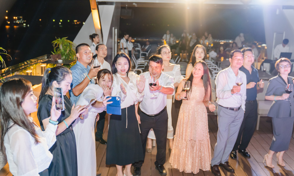 a bunch of halong visitors have fun together on the deck at night