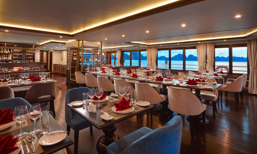 Side view of the restaurant with square wooden tables and blue armchairs.