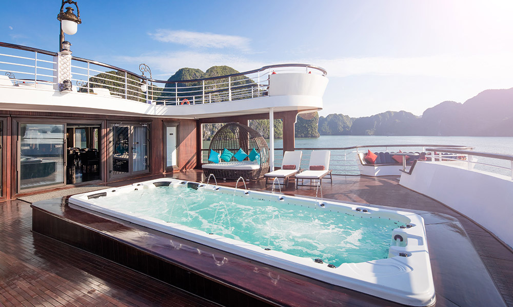 A sundeck with a jacuzzi on the first level and a balcony on the second level.