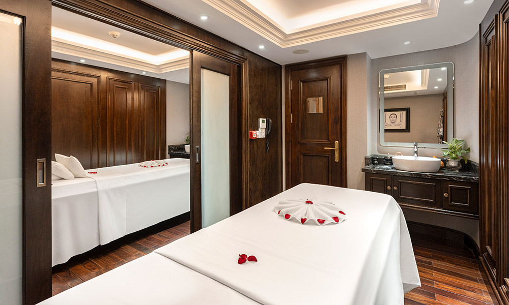 A spa room with two beds with a door in the middle.