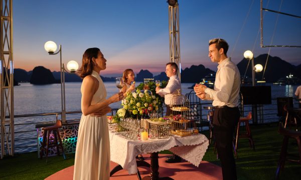 Four guests enjoying drinks on a cruise with Halong sunset.