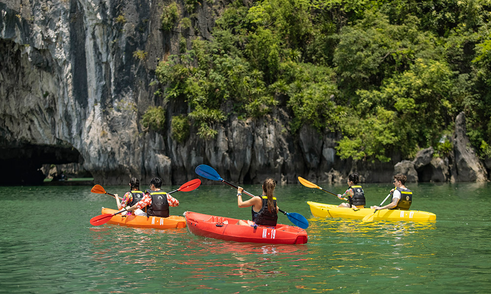 A few kayaks with yellow, red, and orange colors in Halong Bay.