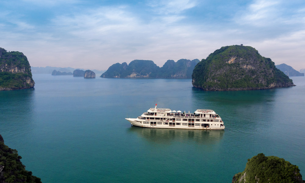 Halong Bay islands and sea panorama with Athena Luxury cruise in the middle.