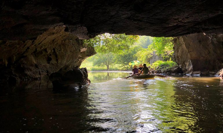 View from inside a cave in Trang An with an opening view of a forest.