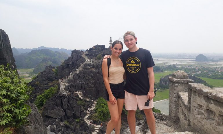 A couple with view of Hang Mua viewpoint behind.