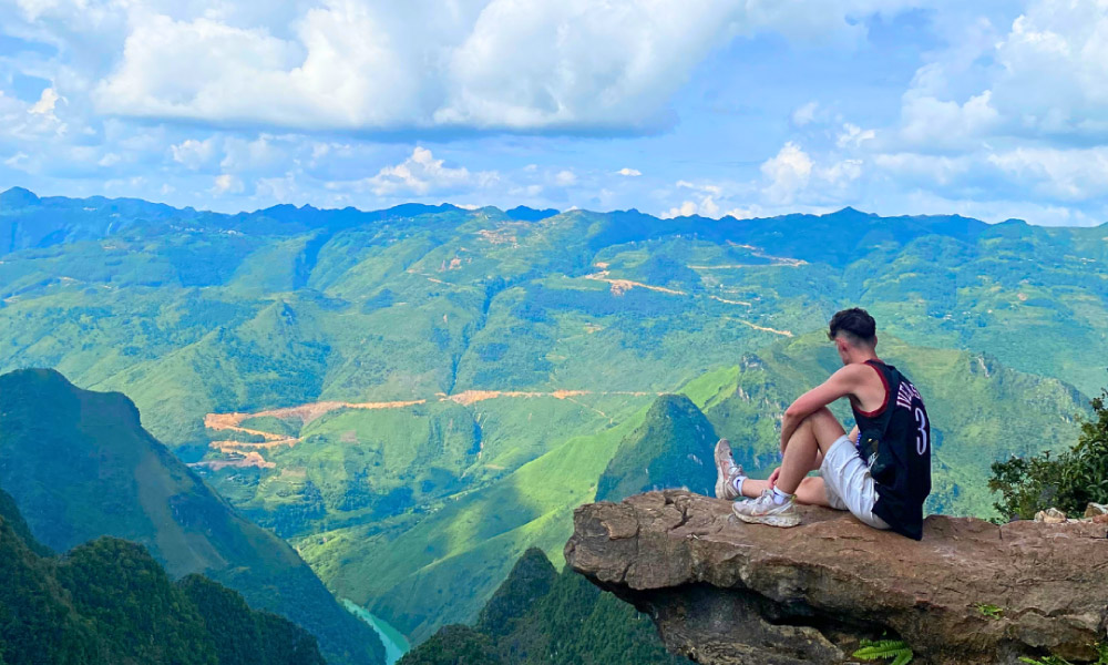 A men sitting on Ma Pi Leng sky walk.