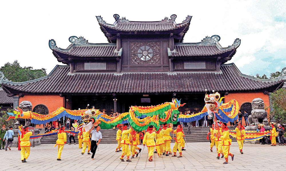 People doing dragon dance in front of Bai Dinh pagoda.