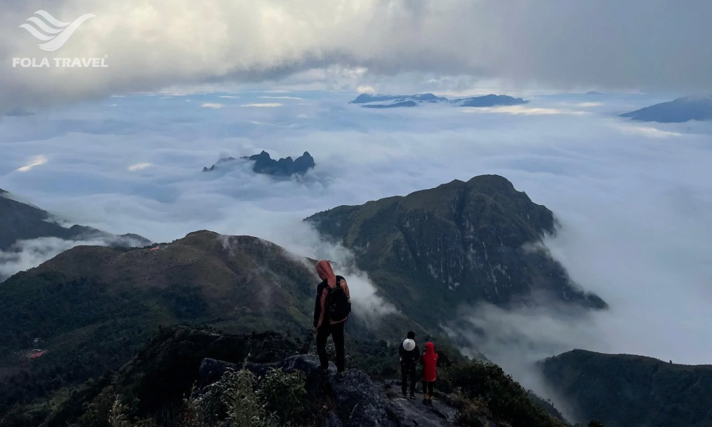 People on top of the mountains in sapa submerged in a sea of cloud.