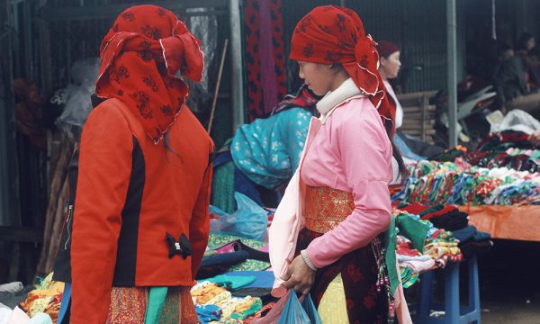 Two gril wearing colorful clothes in a Ha Giang village.