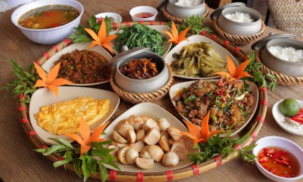 Table full of Vietnamese dishes and rice.