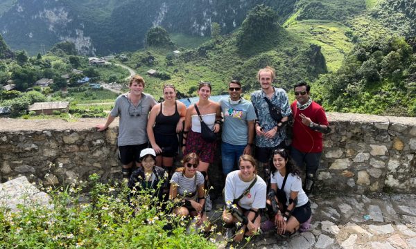 A group in front of Ha Giang mountain and village.