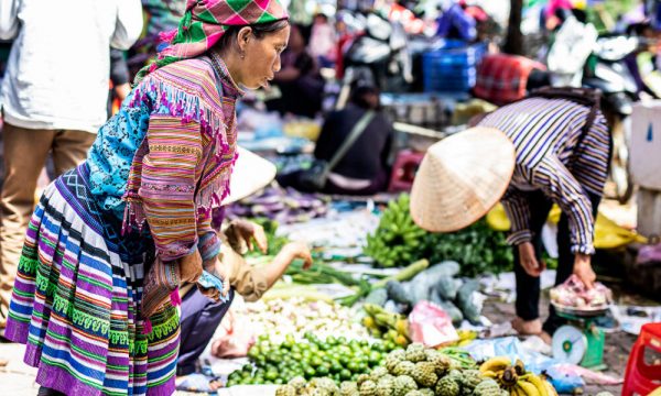 People buying and selling inside a market.