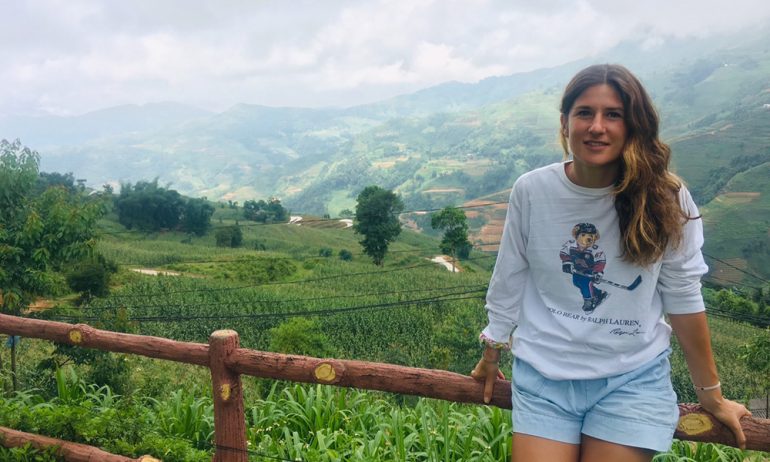 A woman on the right and view of Ha Giang mountains on the left.