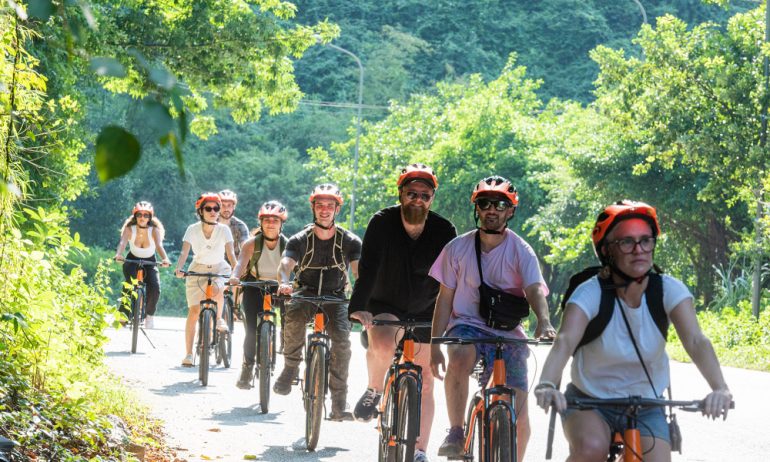 Row of Ninh Binh guests cycling in the middle of nature.