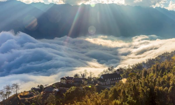 Houses on the top of Sapa mountains with sea of clouds outside.