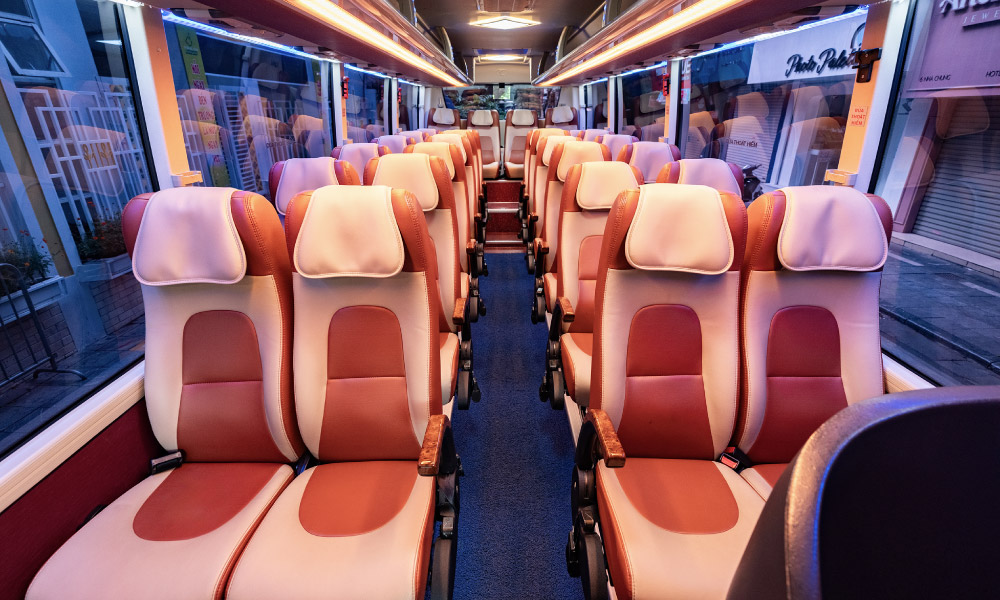 The pink seats inside a shuttle bus.