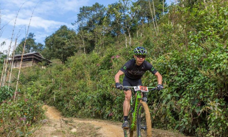 A man cycling on a dirt trail.