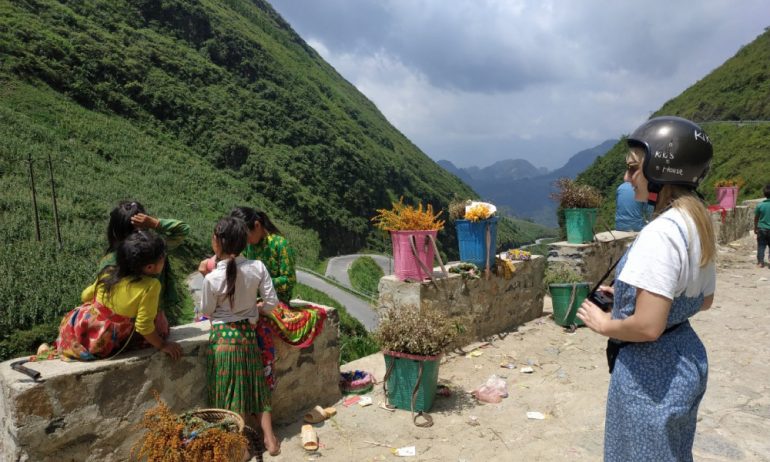 A girld seeing four ethnic girls on the road.