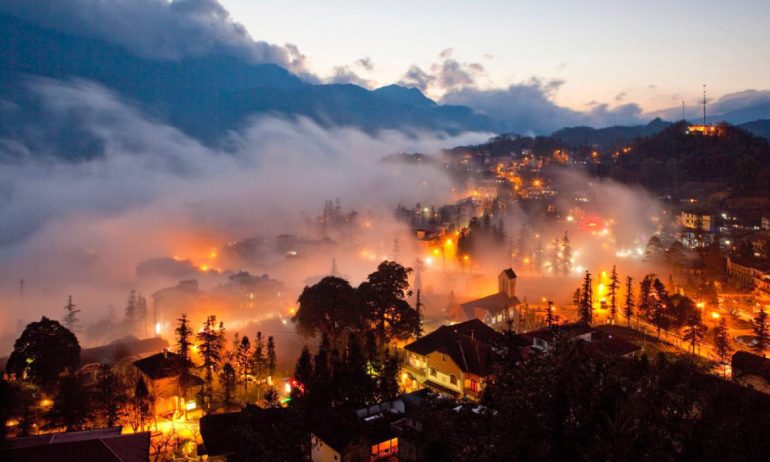 Houses in Sapa light up in the evening.