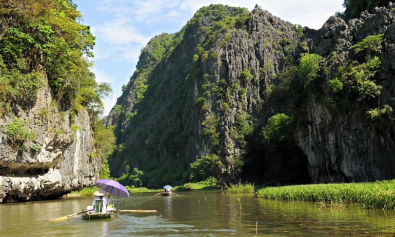 Two boats rowing among the mountans in Tam Coc.