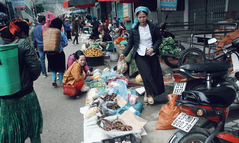 A corner in ha Giang market with a stall selling vegetables.