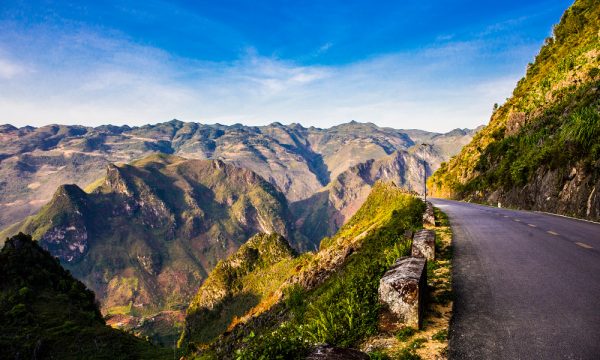 A road on the right and Ha Giang stone mountains on the left.