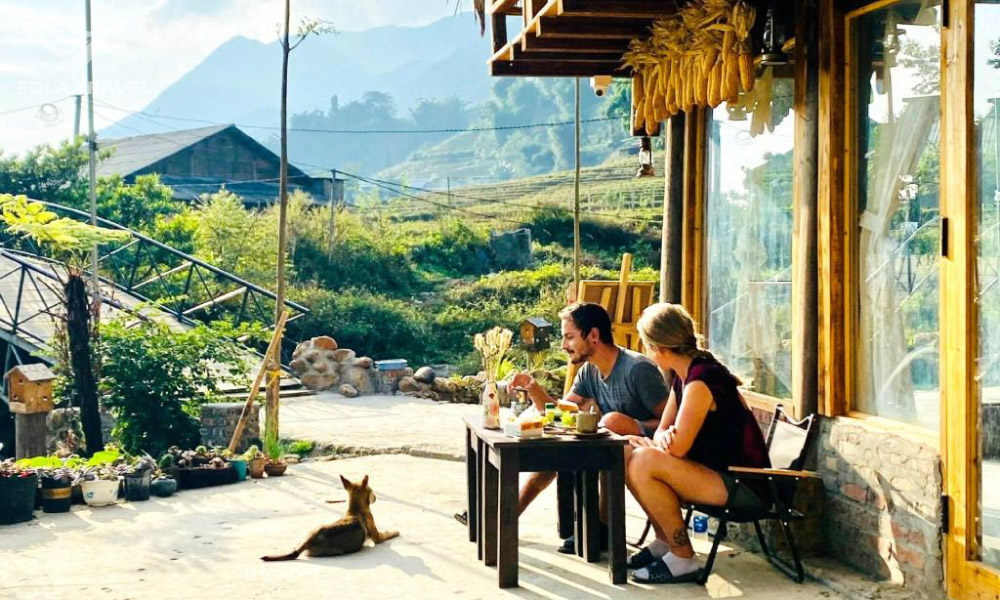 Two people on a table outside a house.