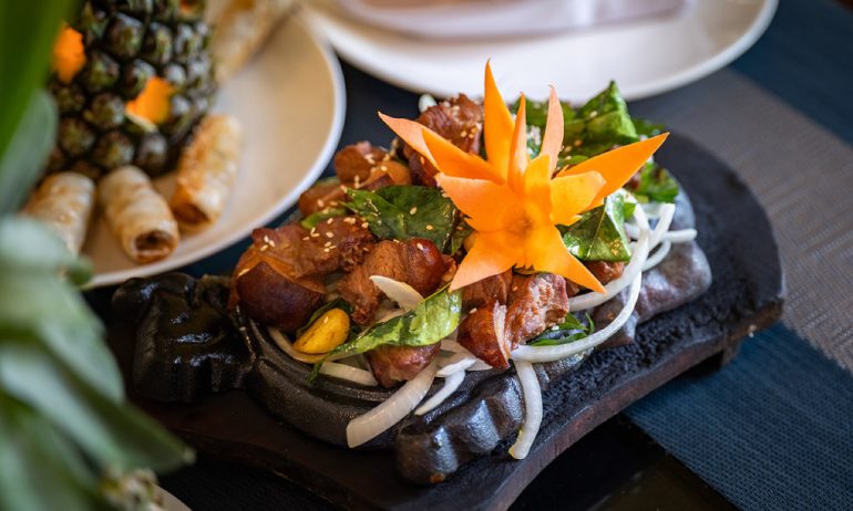 Hot small stone plate of sliced stir fried beef.