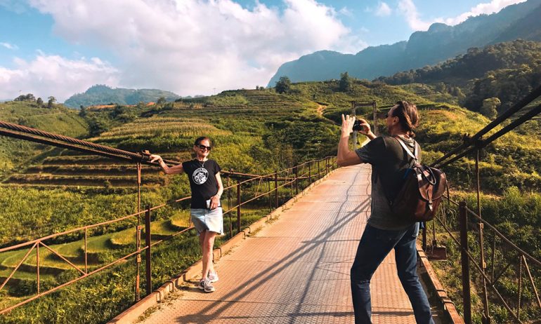 A man taking photos of a woman among Ha Giang rice terraces.