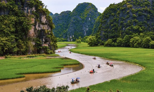 Tam Coc view with a river among the green fields and mountains,