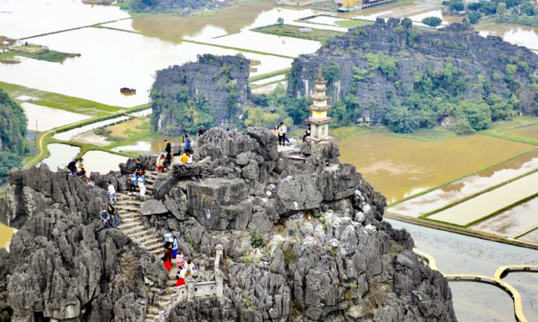 Panorama of Hang Mua peak with many people standing.