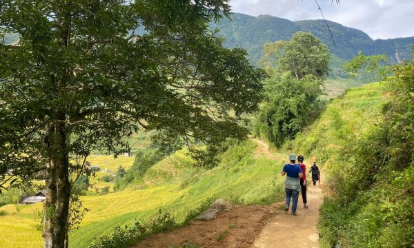 Three people walking down a dirt trail in Sapa.