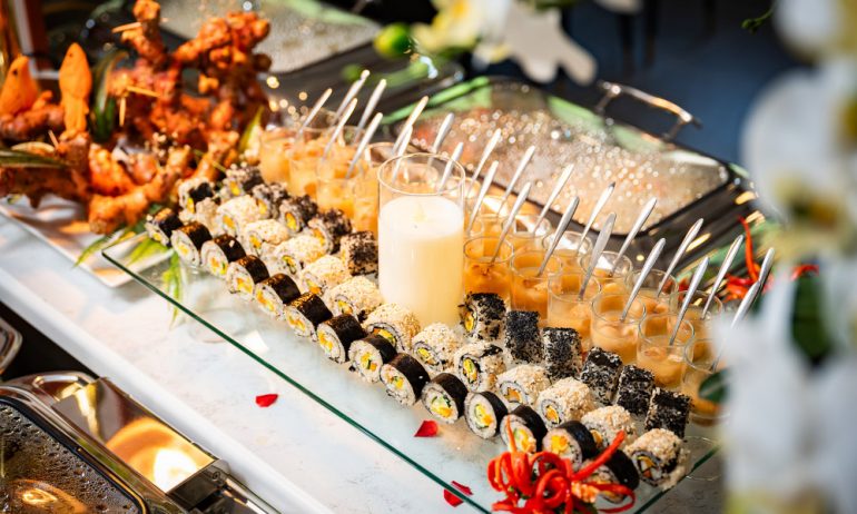 Glass tray of sushi and sauces.