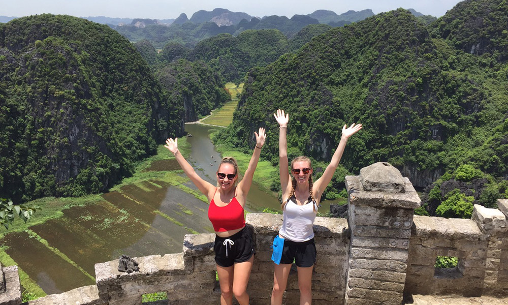 Two girl standing in front of Tam Coc view.