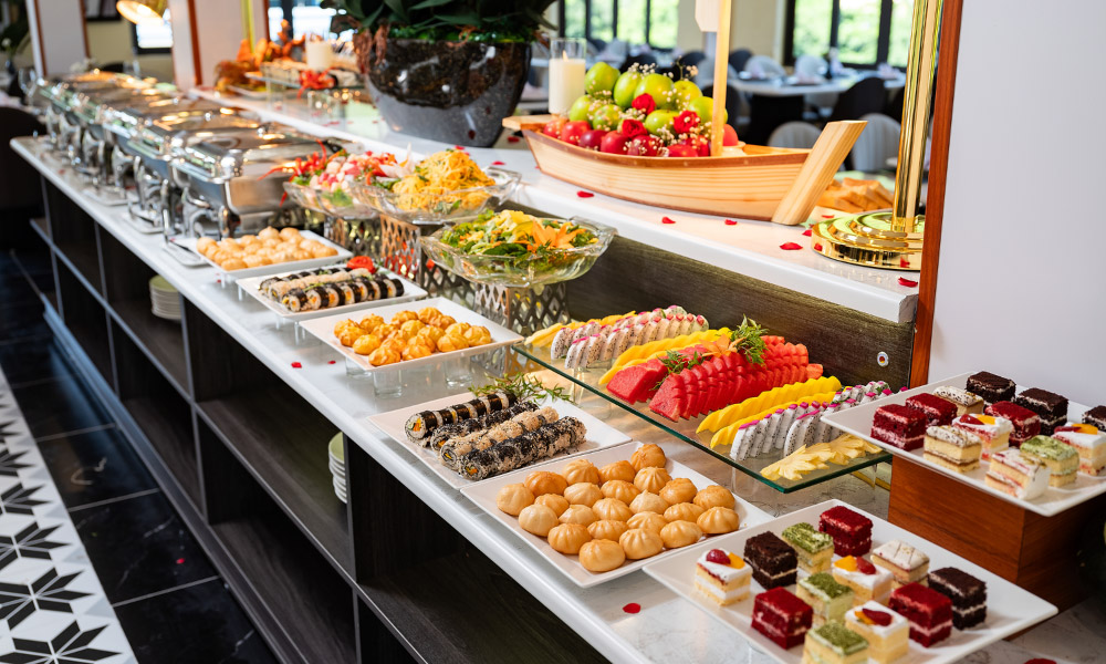 Buffet station with cakes and fruits in Cozy Ninh Binh restaurant.