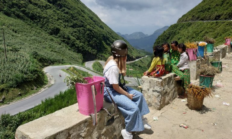 A girl with four ethnic children looking out to Tham Ma Pass in Ha Giang.