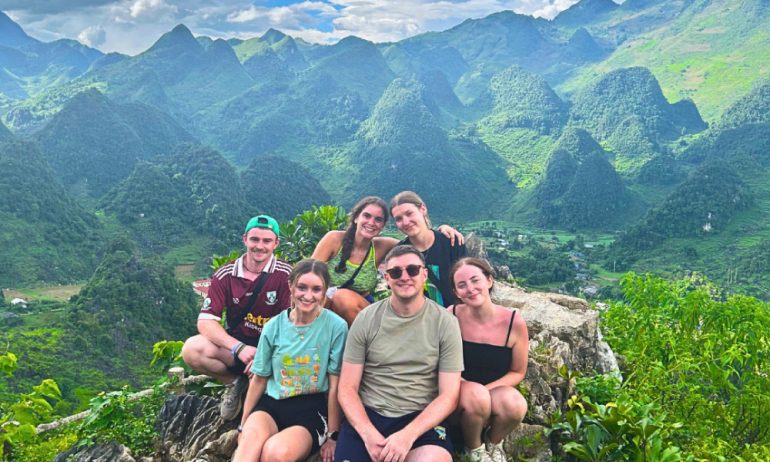 Group of people overlooking Ha Giang mountains.