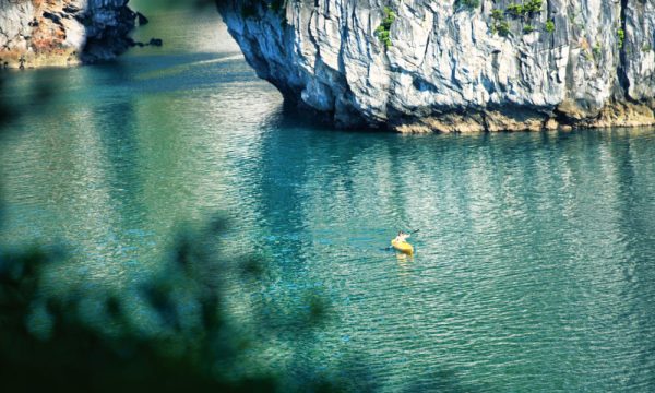A small yellow kayak in Bai Tu Long water.