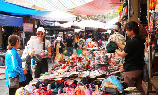 Foreign guest buying brocade in Bac Ha Market.