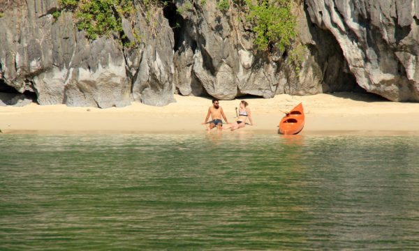 A couple chilling on a beach in Lan Ha Bay.