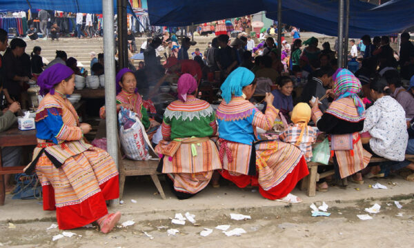 Local women sitting in food stall in Bac Ha Market.