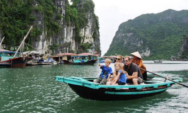 A family visiting Cua Van Fishing Village on a boat.
