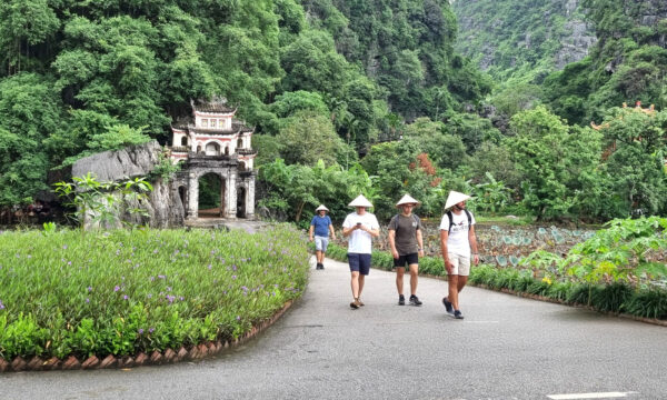 Guests walking in the path through Bich Dong lotus pond.