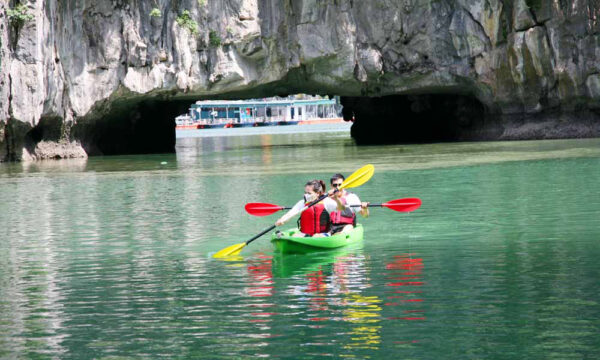 Kayaking under a cave in Halong Bay.