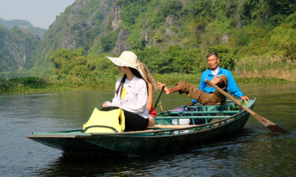 Local rowing boat by legs in Tam Coc.
