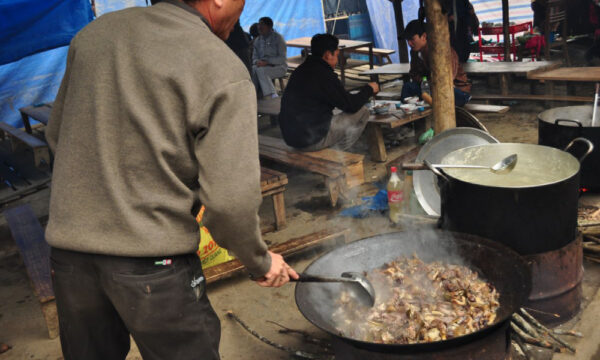 A local person making food in Bac Ha Market.