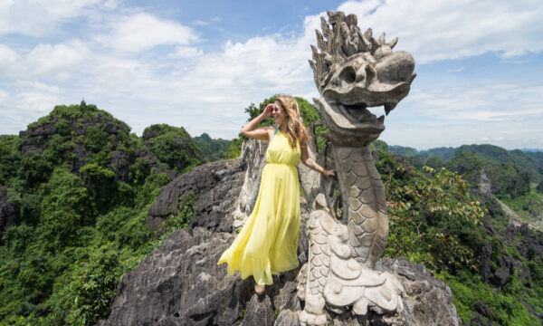 Girl at the stone dragon in Mua Caves.