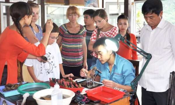 Guests watching artisan making pearl jewelry.